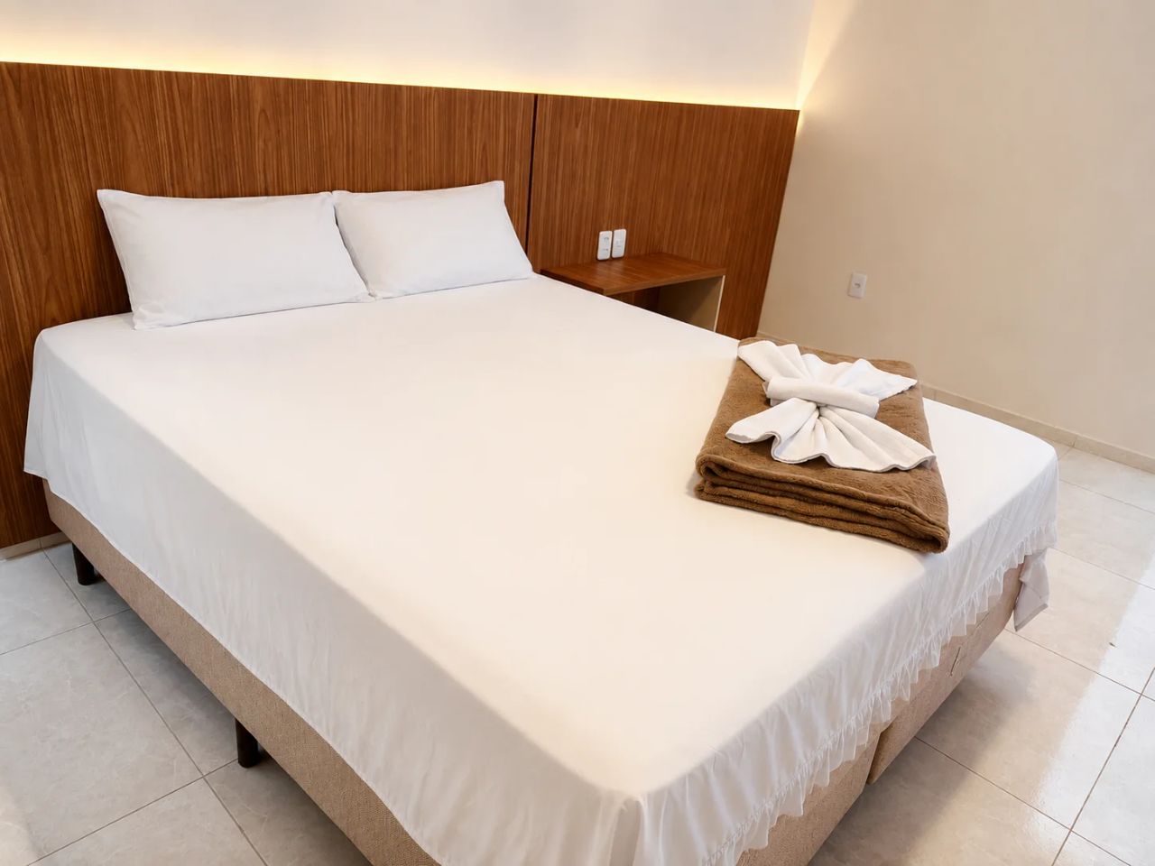 Suíte Comfort com cama de casal preparada para o hóspede